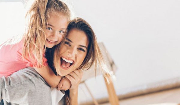 uśmiechnięta kobieta, która ma piękny brzuch po&nbsp;ciąży