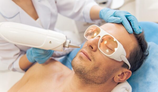 Mężczyzna na zabiegu laserowym w salonie kosmetycznym